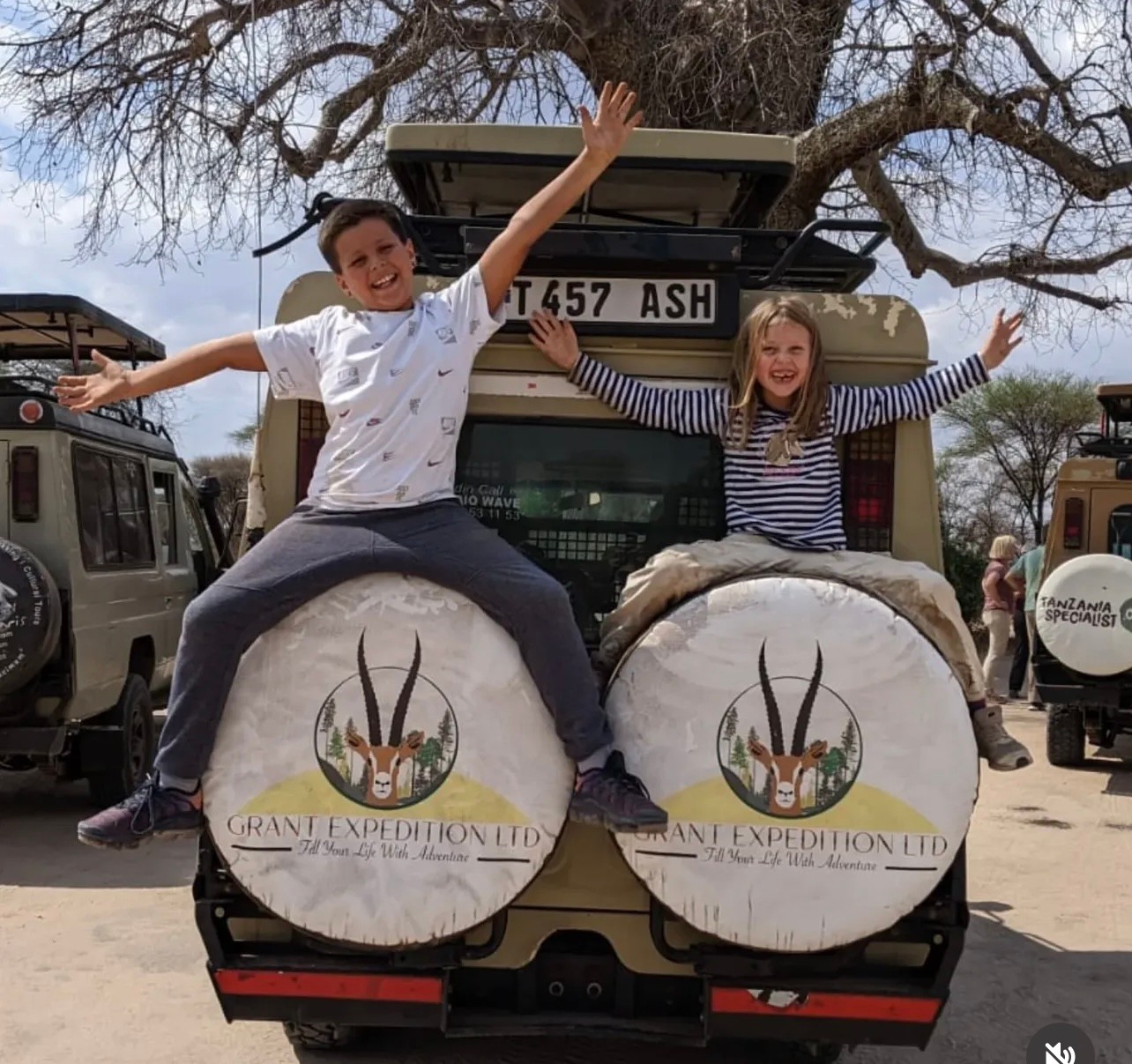Guests sitting on the back of a safari vehicle